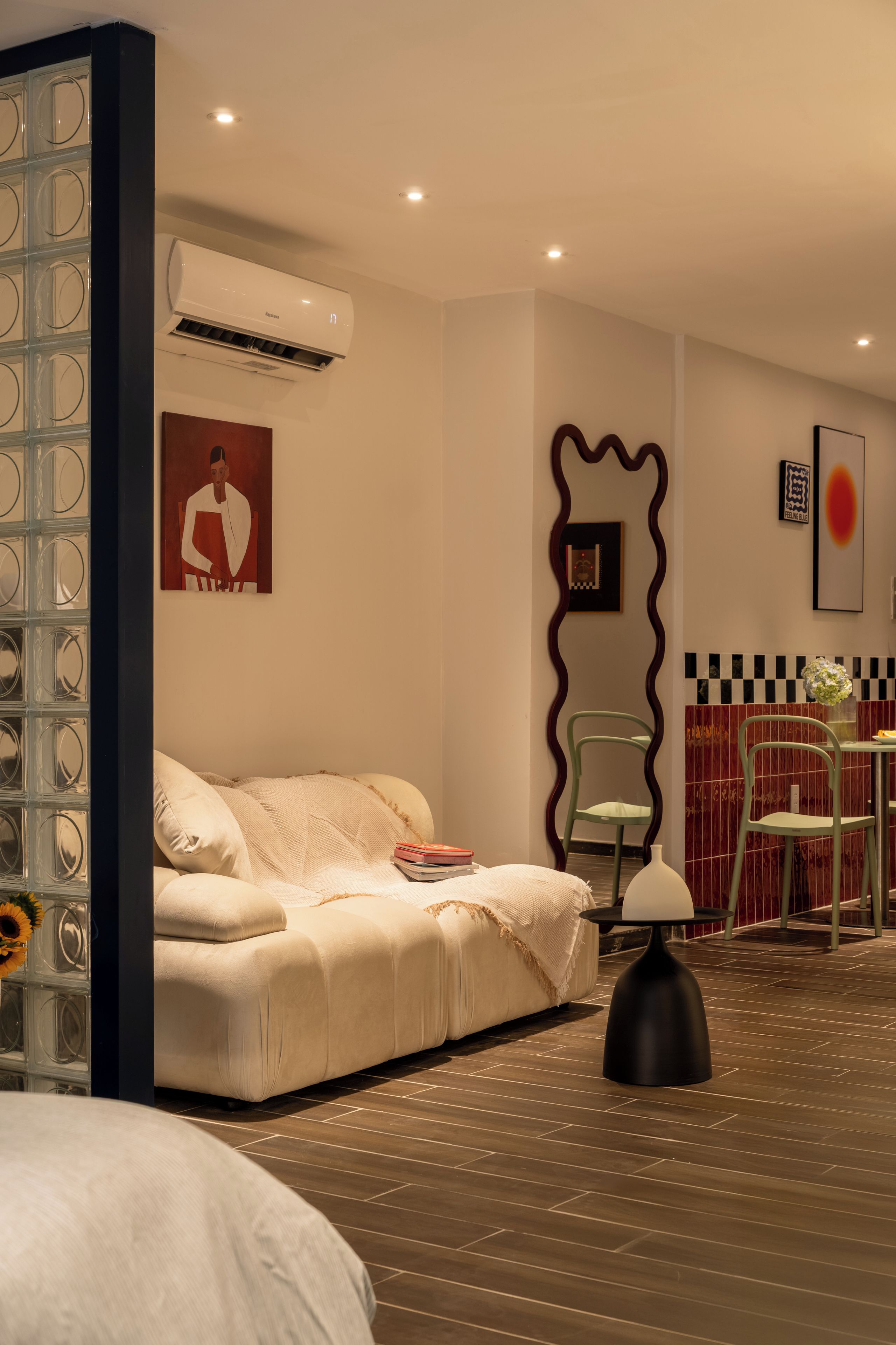 Une chambre d’hôtel moderne, équipée d’un canapé, d’un fauteuil, d’une table et d’un miroir décoratif.