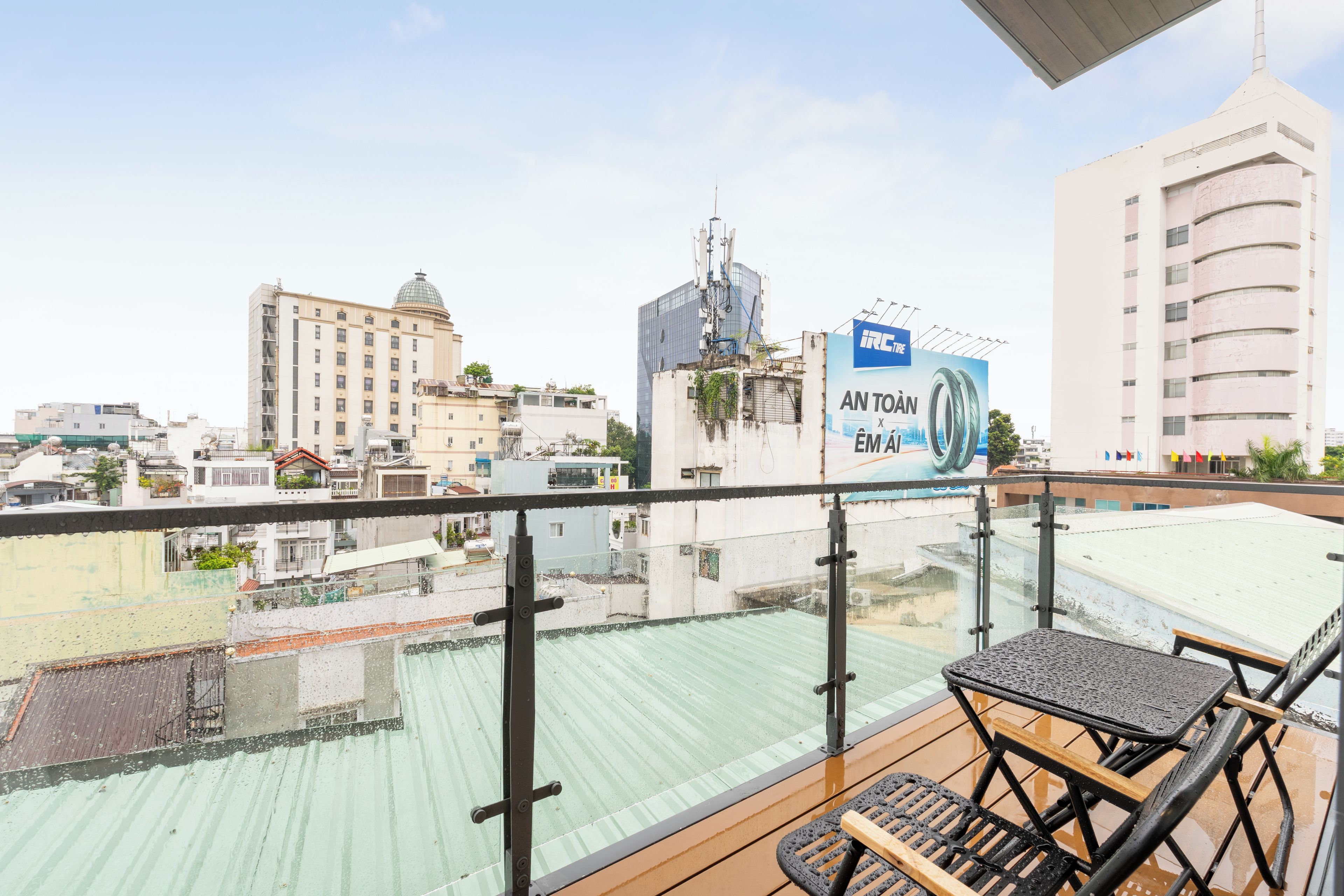 Un balcon offrant une vue sur le paysage urbain, avec notamment un bâtiment surmonté d’un dôme et une structure moderne en verre.
