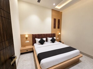 Habitación de hotel moderna con una cama grande, cabecero de madera, lámparas de noche y suelo de mármol.