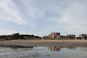 Ein Strand mit Gebäuden im Hintergrund.