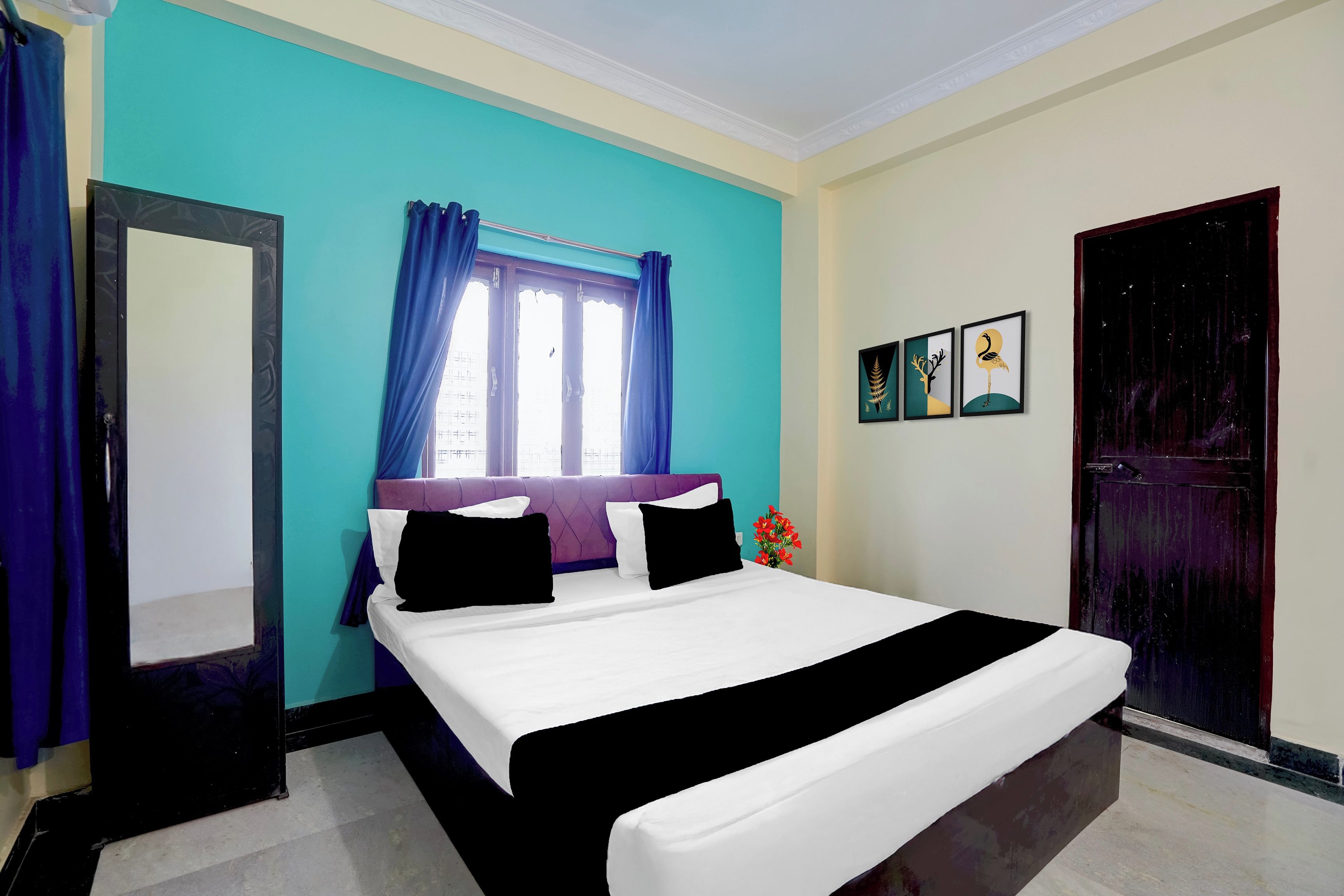 Un dormitorio con cama, ventana con cortinas, puerta y decoración en la pared.