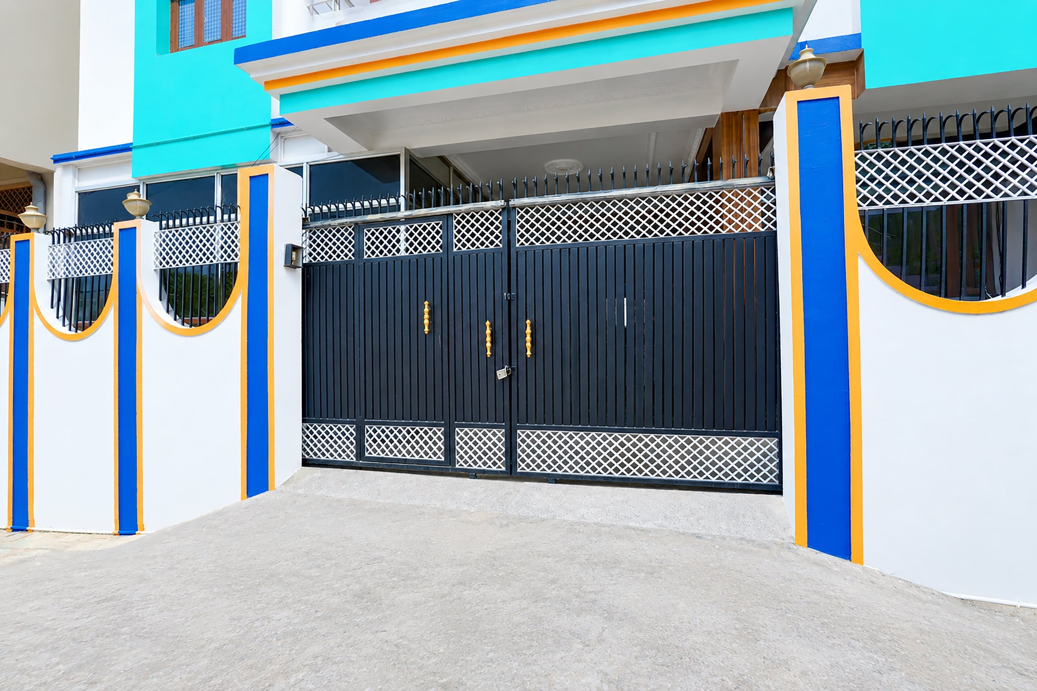 A gated entrance with a blue and white building in the background.