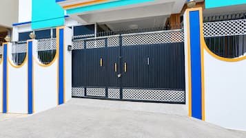 A gated entrance with a blue and white building in the background.