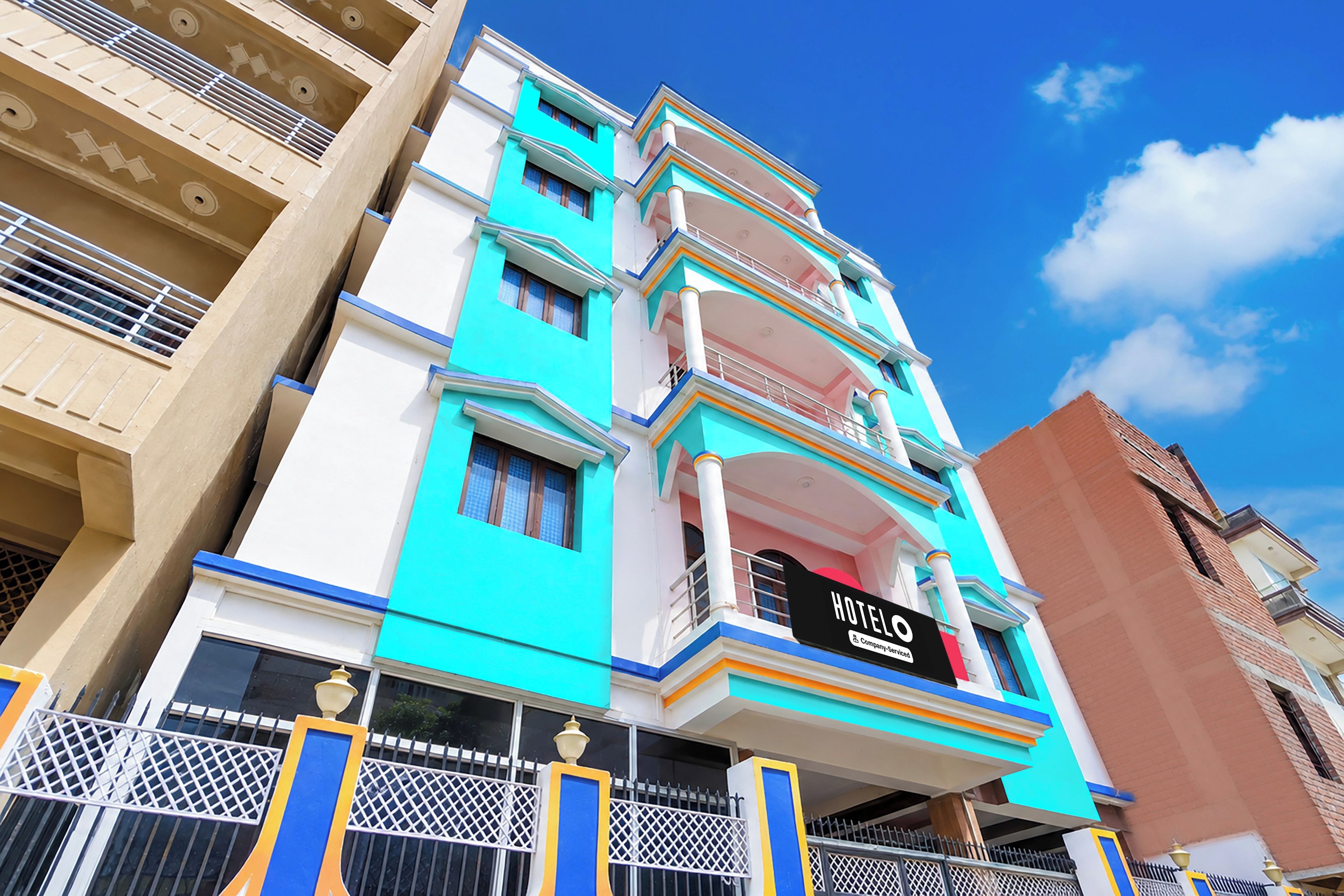 Un hotel de varios pisos con un llamativo letrero que dice 'HOTEL' en la fachada, con balcones y un diseño arquitectónico moderno.