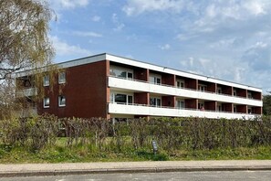 A multi-story building with a flat roof, rectangular windows, and a balcony on the upper floor. - Berliner Ring - Apt. 27 (Wyk auf Föhr)