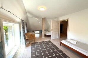 A room with a bed, a window with curtains, a wooden floor, and a ceiling light. - Holiday home in Oldsum with swimming pool (Oldsum)