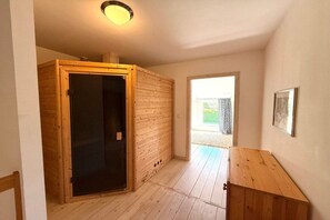 A room with a wooden door, a wooden cabinet, and a framed picture on the wall. - Holiday home in Oldsum with swimming pool (Oldsum)