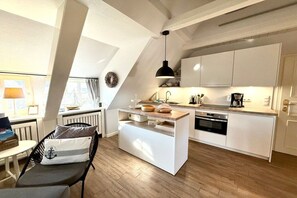 A modern kitchen with white cabinetry, a central island, and a pendant light. - 3 in the Deichhof house (Dunsum)