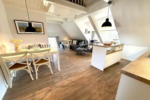 A modern loft-style living space with a dining area, kitchen, and seating area. - 3 in the Deichhof house (Dunsum)