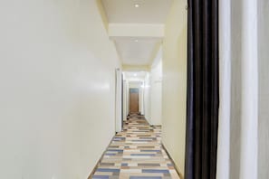 A narrow hallway with a patterned floor leading to a door at the end. - Hotel O IIT Varanasi Shree Gopal Upwan  (Varanasi)