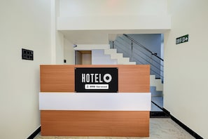 A hotel reception desk with a sign indicating it is OYO-Serviced.