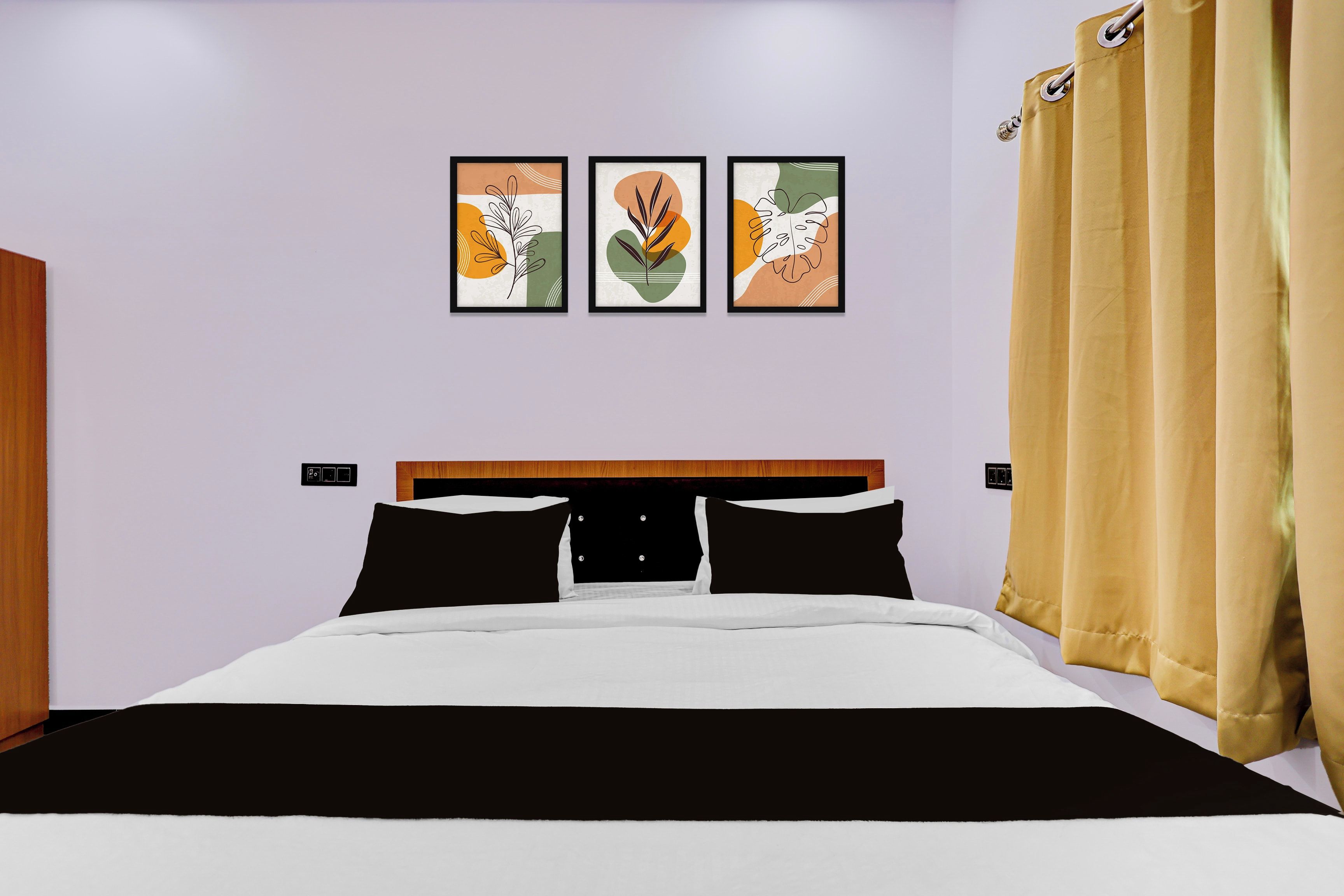 Un dormitorio con una cama, cabecera y tres cuadros en la pared.
