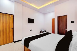 A hotel room with a bed, a desk, a TV, and a wardrobe. - Super Hotel O AIIMS Nagpur (Nagpur)
