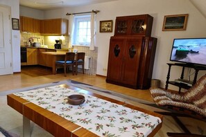 A living room with a wooden coffee table, a television, and a leopard print chair. - Holiday home in Nieblum with swimming pool (Nieblum)