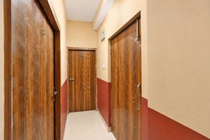 A hallway with wooden doors, each marked with a number. - Hotel O Patliputra Golmber Patna Suncity (Patna)