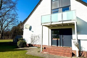 A modern two-story building with a satellite dish, a balcony, and a front door. - Holiday apartment in Wyk on Föhr with sauna (Wyk auf Föhr)