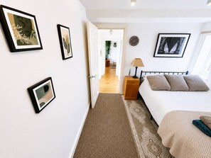 Ein Schlafzimmer mit Bett, Nachttisch, Lampe und Wanduhr.