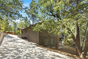 A two-story house with a covered porch and a visible staircase leading to the second floor. - PET FRIENDLY! Fenced Yard! Game Room! Flat Driveway! (Big Bear Lake)