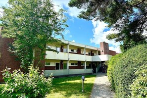 A two-story building with a brick facade, a flat roof, and a central staircase leading to an upper level. - Holiday apartment in Wyk with swimming pool (Wyk)