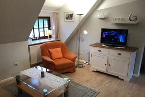 A living room with a television, a sofa, a coffee table, and a cabinet. - Hansen Nieblum - Holiday Apartment 2 (Nieblum)