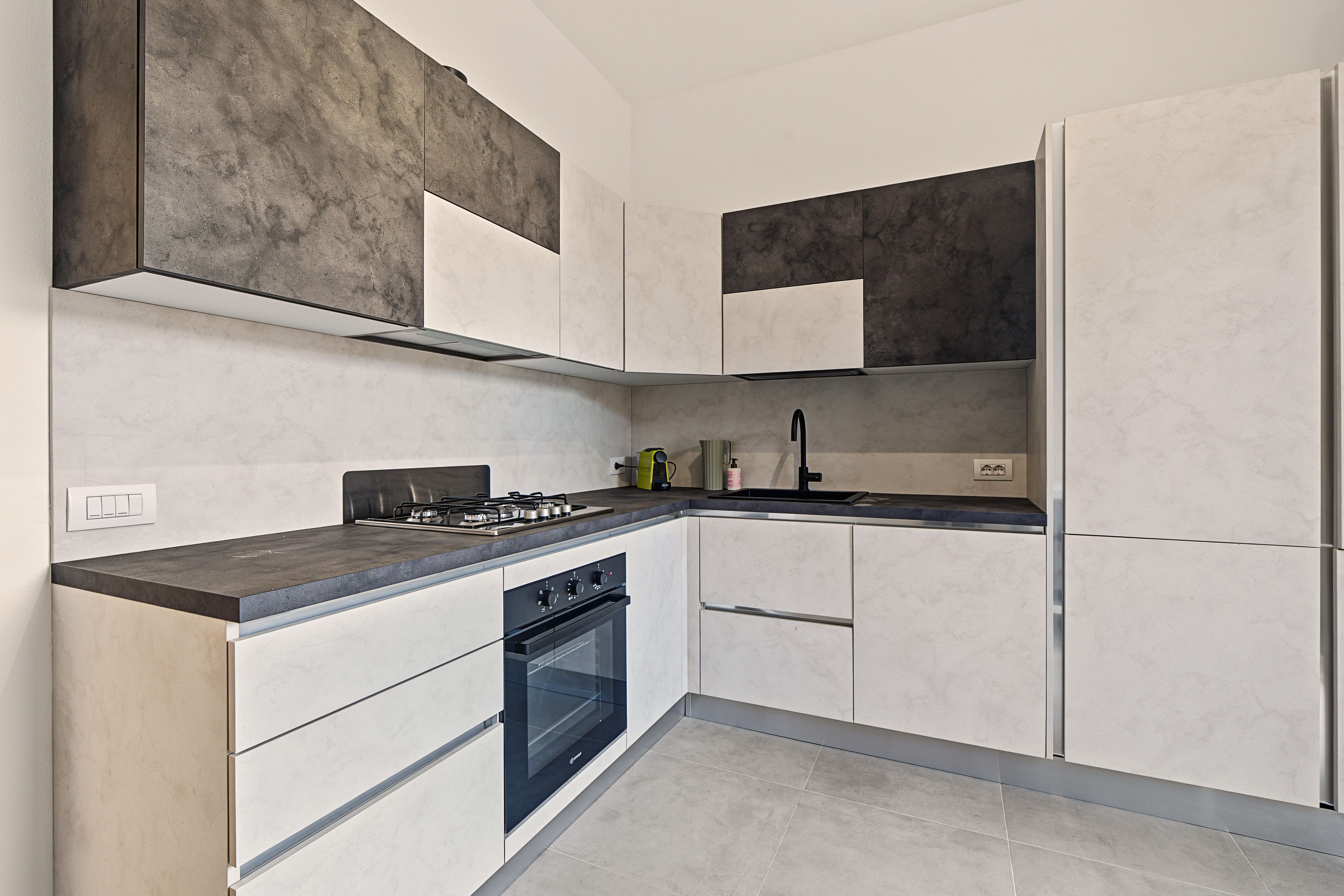 Eine moderne Küche mit Gasherd, Backofen und integriertem Geschirrspüler.