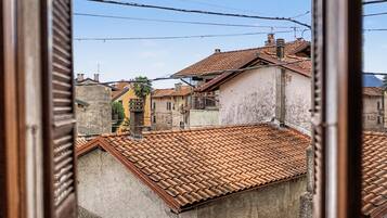 Vue d’un quartier résidentiel avec des toits recouverts de tuiles en terre cuite, un mélange de styles architecturaux et des lignes électriques apparentes.