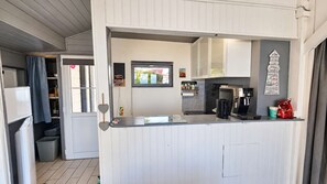 A compact kitchenette with a coffee machine, a small refrigerator, and a window with a view of the outside. - Sea breeze, ocean view, and direct beach access (Saint-Côme-de-Fresné)