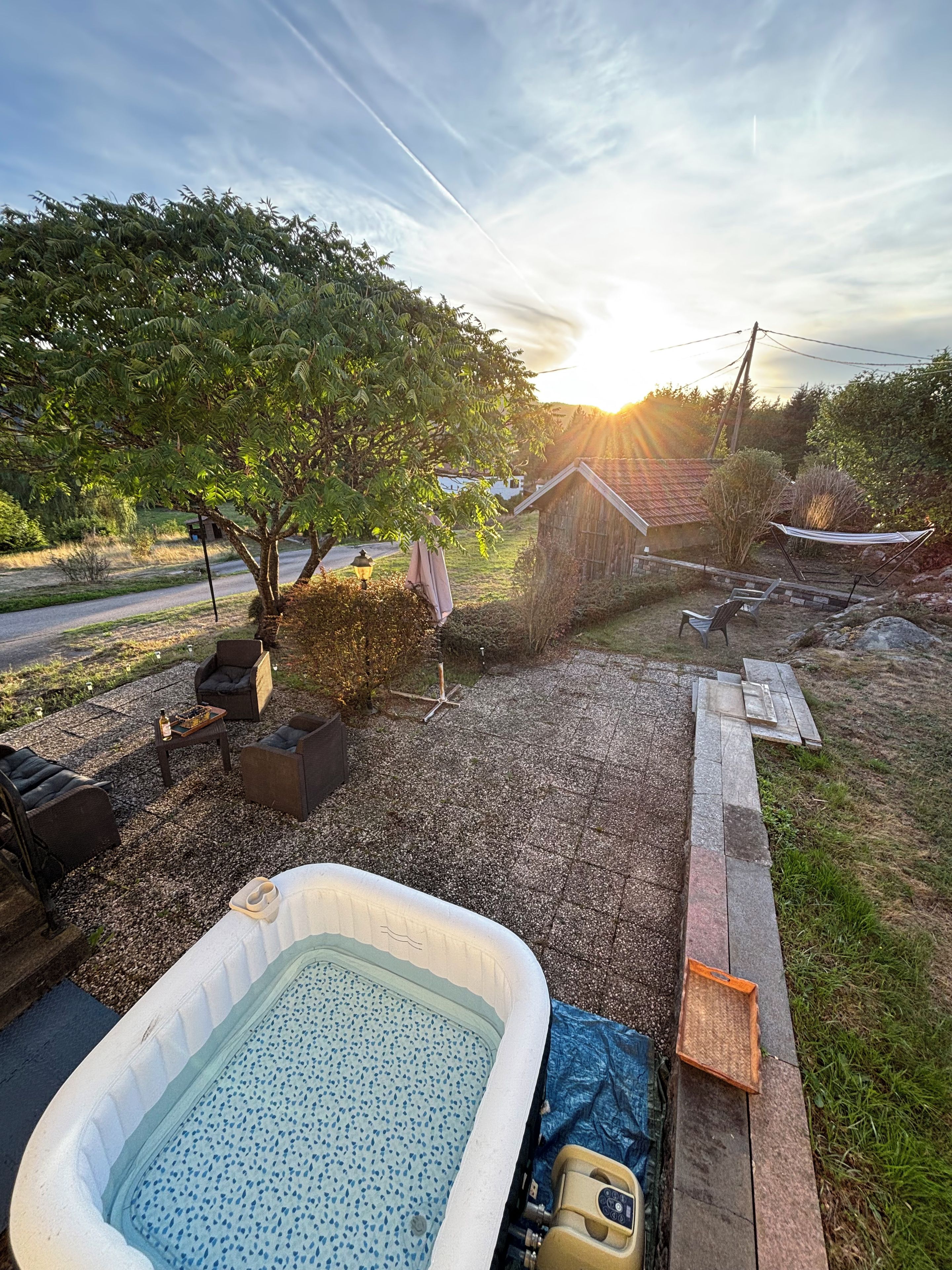 Ein Garten mit Whirlpool, Gartenmöbeln und einer Holzterrasse.