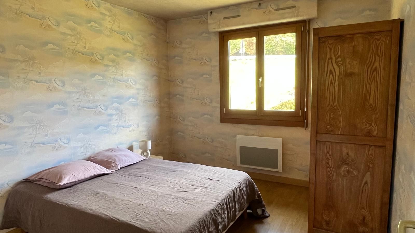 Une chambre à coucher avec un lit, une fenêtre et une armoire.