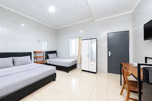 A hotel room with two beds, a desk, a chair, a wardrobe, and a TV. - Ava Guest House Bali (Ungasan)