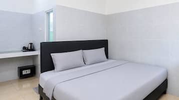 Une chambre moderne avec un lit simple, une table de chevet, une prise de courant et une fenêtre.