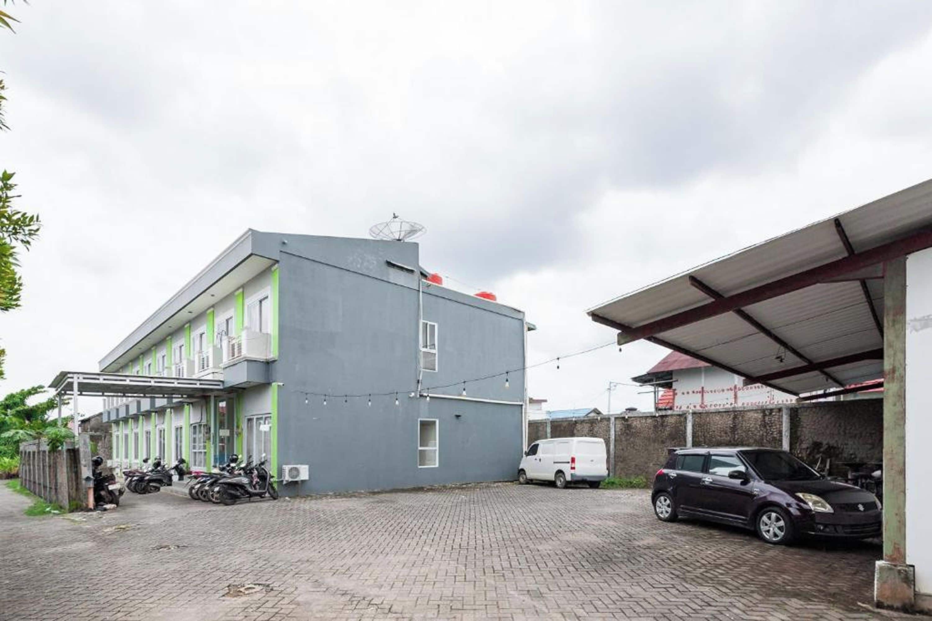 Un bâtiment doté d’un toit plat, d’une antenne parabolique et d’un espace de stationnement couvert.