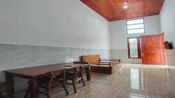 A spacious room with a wooden dining table and chairs, a bench, and a large wardrobe.