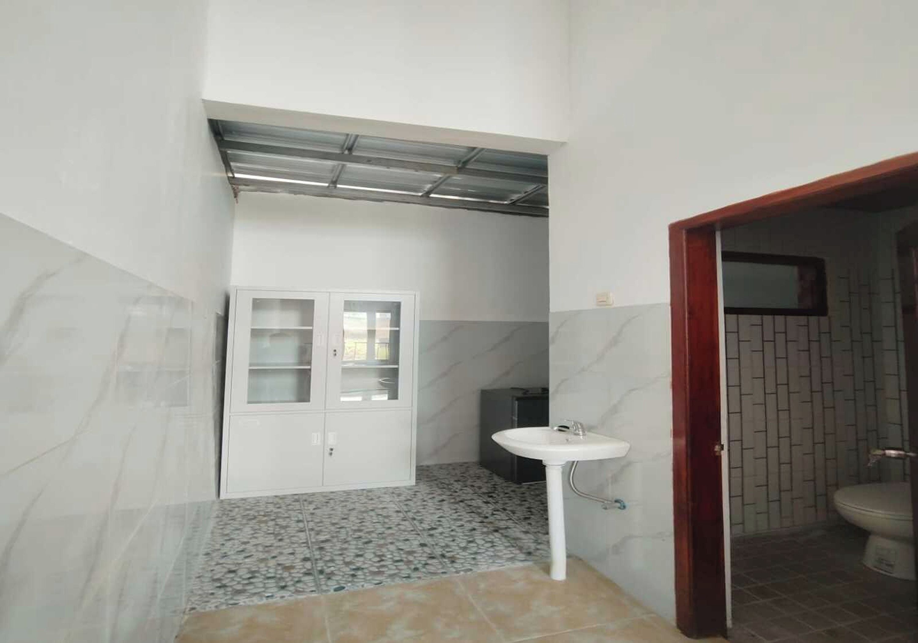 A bathroom with a white sink, a cabinet, and a tiled floor.