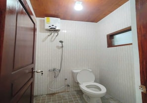 Ein kleines Badezimmer mit Toilette, Dusche und einem Wandheizkörper.