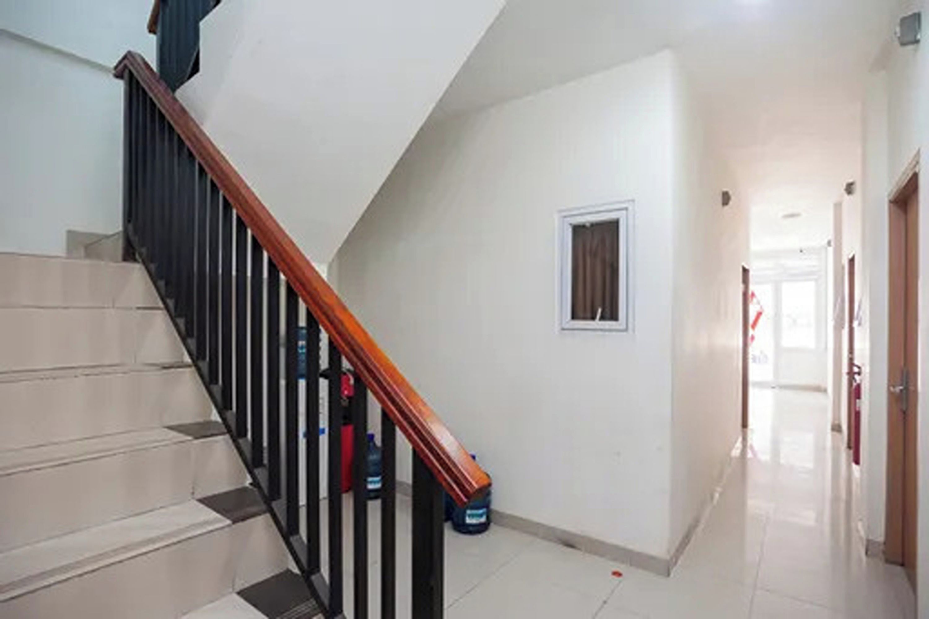 A staircase with a wooden handrail leading to an upper floor.