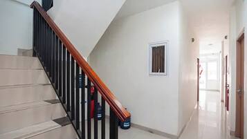 A staircase with a wooden handrail leading to an upper floor.
