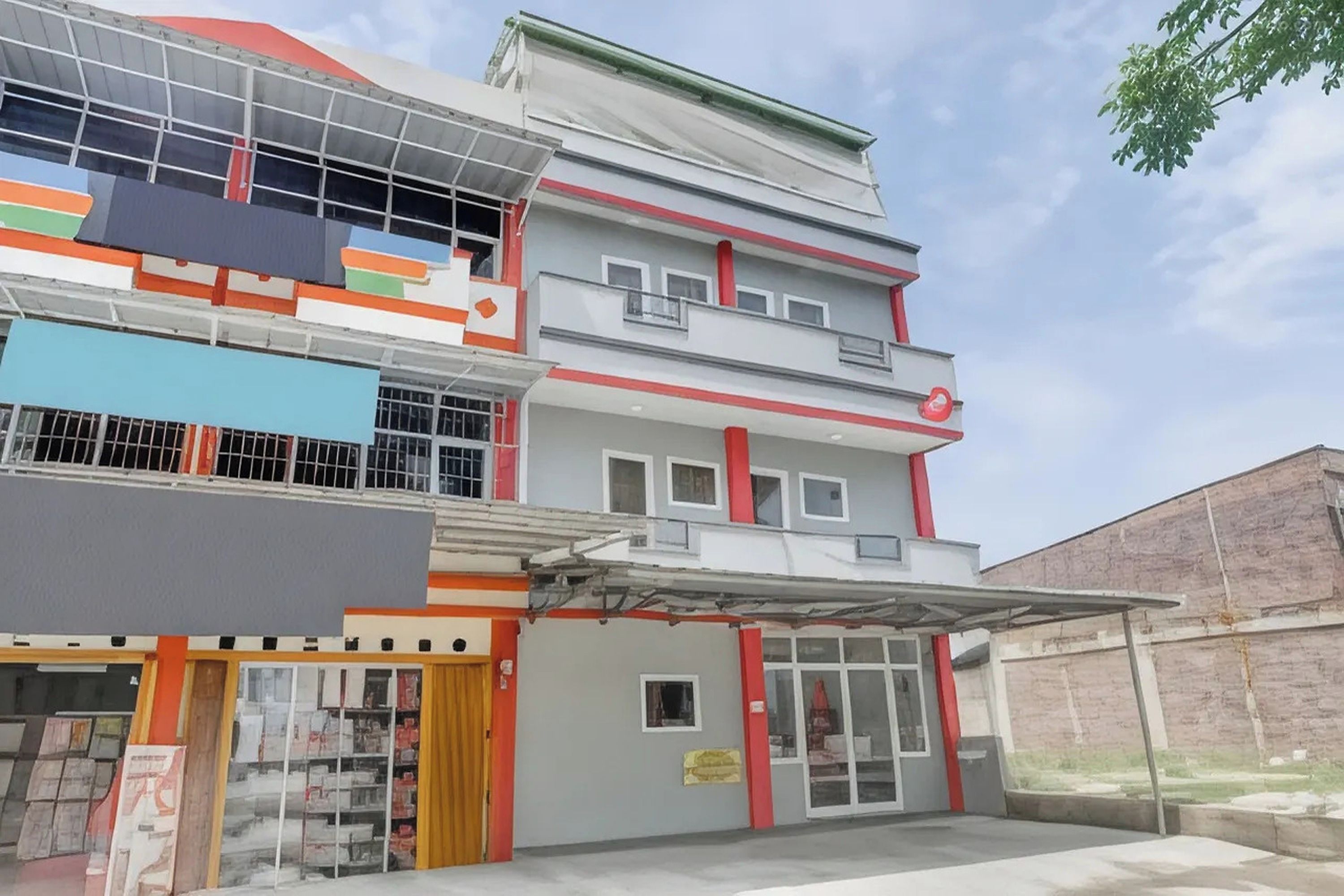 A multi-story building with a garage entrance, a storefront on the ground floor, and a balcony on the upper floors.