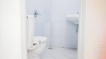Ein Badezimmer mit Toilette, Waschbecken und Fliesen.