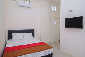 Une chambre d’hôtel avec un lit, une télévision et une fenêtre.