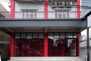 A building with a red and white facade, large windows, and a visible sign for 'KENDALI SODO'.