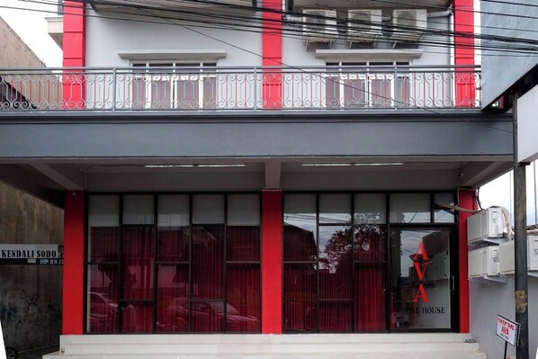 A building with a red and white facade, large windows, and a visible sign for 'KENDALI SODO'. - Ava Guest House Magelang (Magelang)