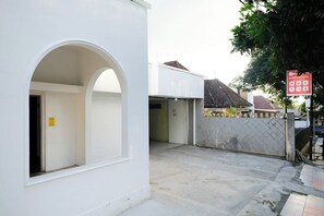 A white building with a large arched doorway and a gated entrance. - Ava Hotel Bayeman Tidar (Magelang)