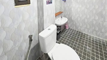 Un baño con inodoro, lavabo y ducha.