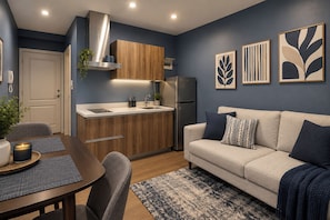 A modern kitchen with wooden cabinets, a stainless steel range hood, and a built-in refrigerator. - Spacious The Gramercy Residences (Makati)