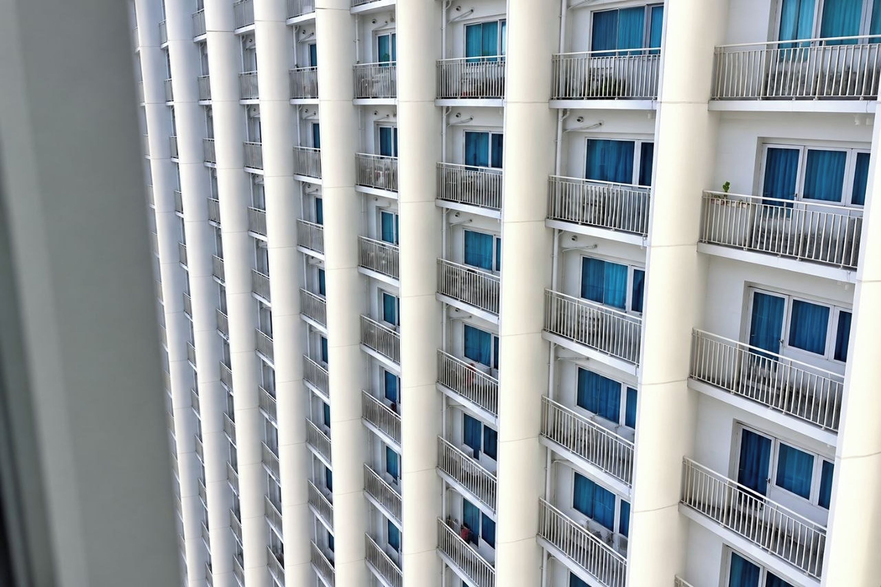 Un hotel de varios pisos con balcones, cada uno con barandilla de metal.