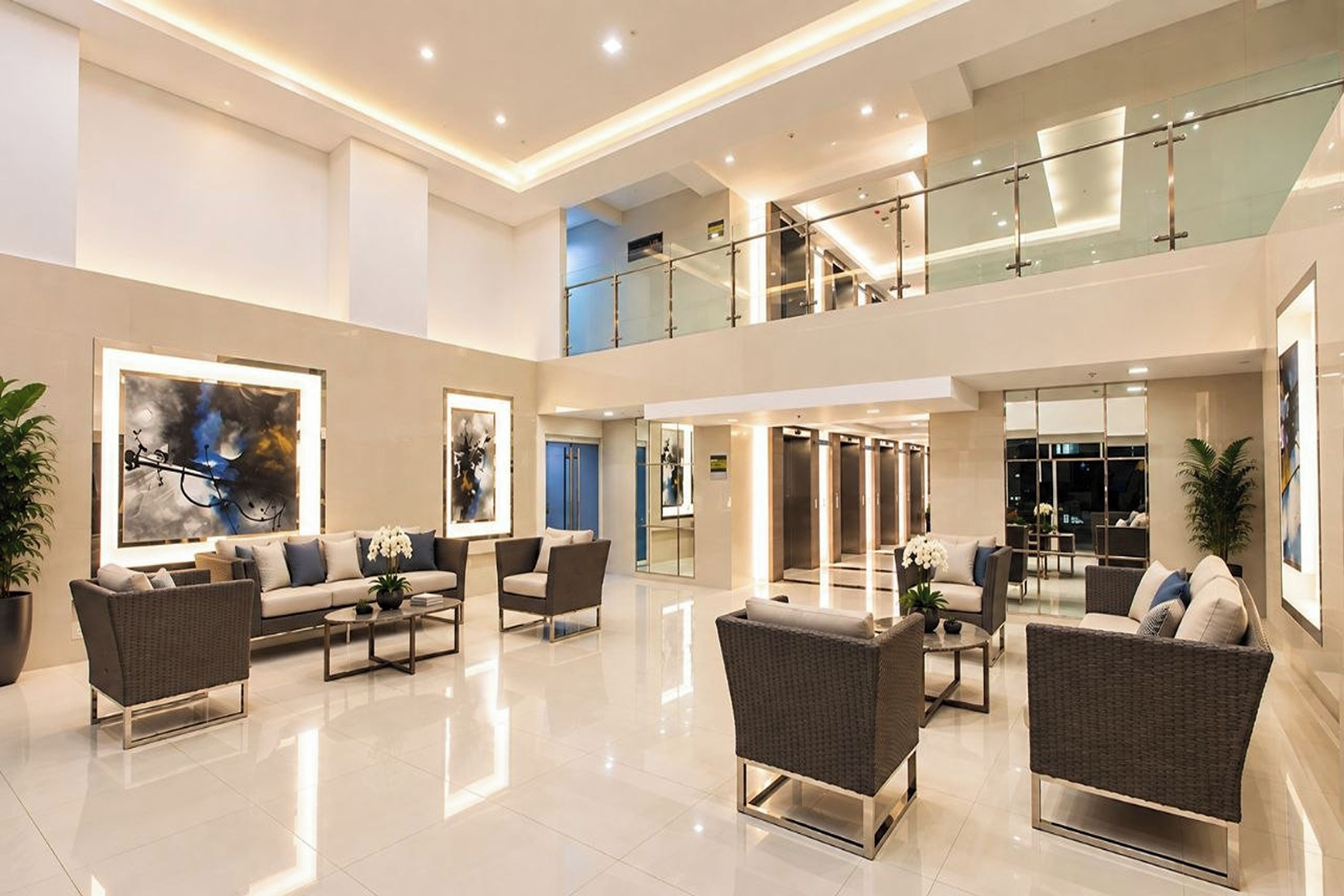 Un lobby amplio con techo alto, muebles modernos y obras de arte en las paredes.