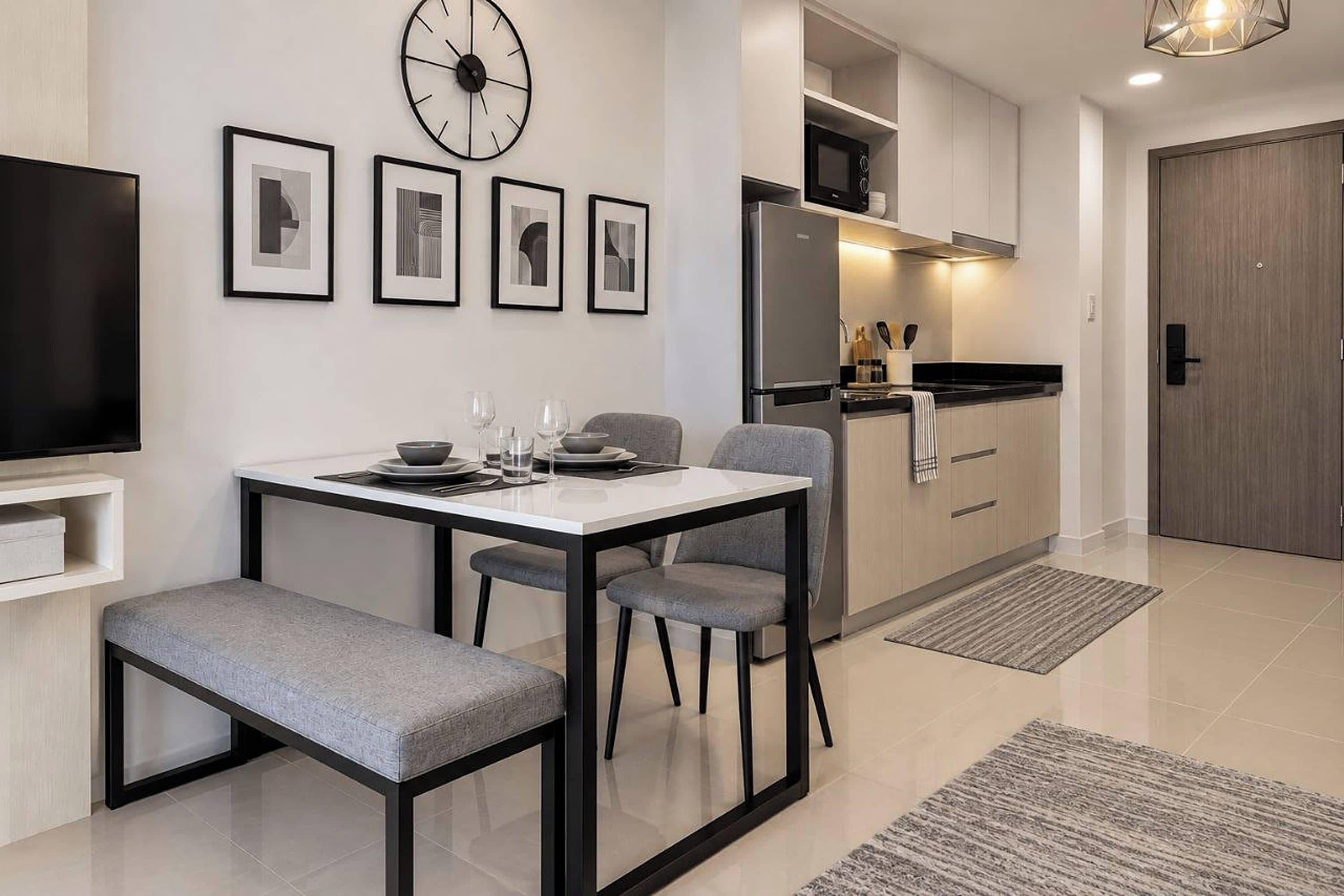 Una cocina moderna con microondas integrado, un refrigerador y un comedor con mesa y sillas.