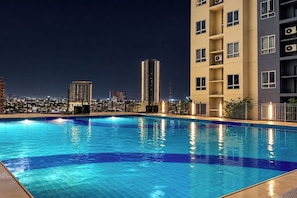 A swimming pool with a cityscape view at night. - Victoria Sports Tower - Tomas Morato (Quezon)