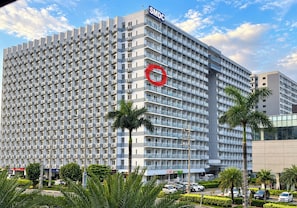 A multi-story hotel with a prominent 'SMDC' sign, numerous balconies, and a parking area with cars. - Shell Residences Cozy Staycation (Pasay)
